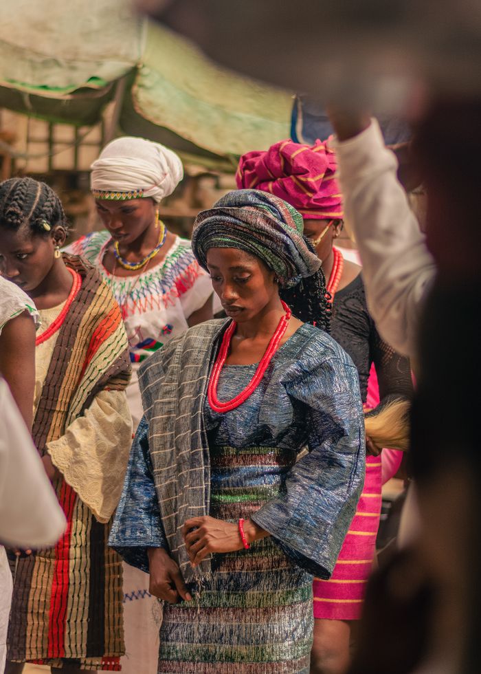 Women dressed in vibrant traditional African clothing at a cultural gathering.