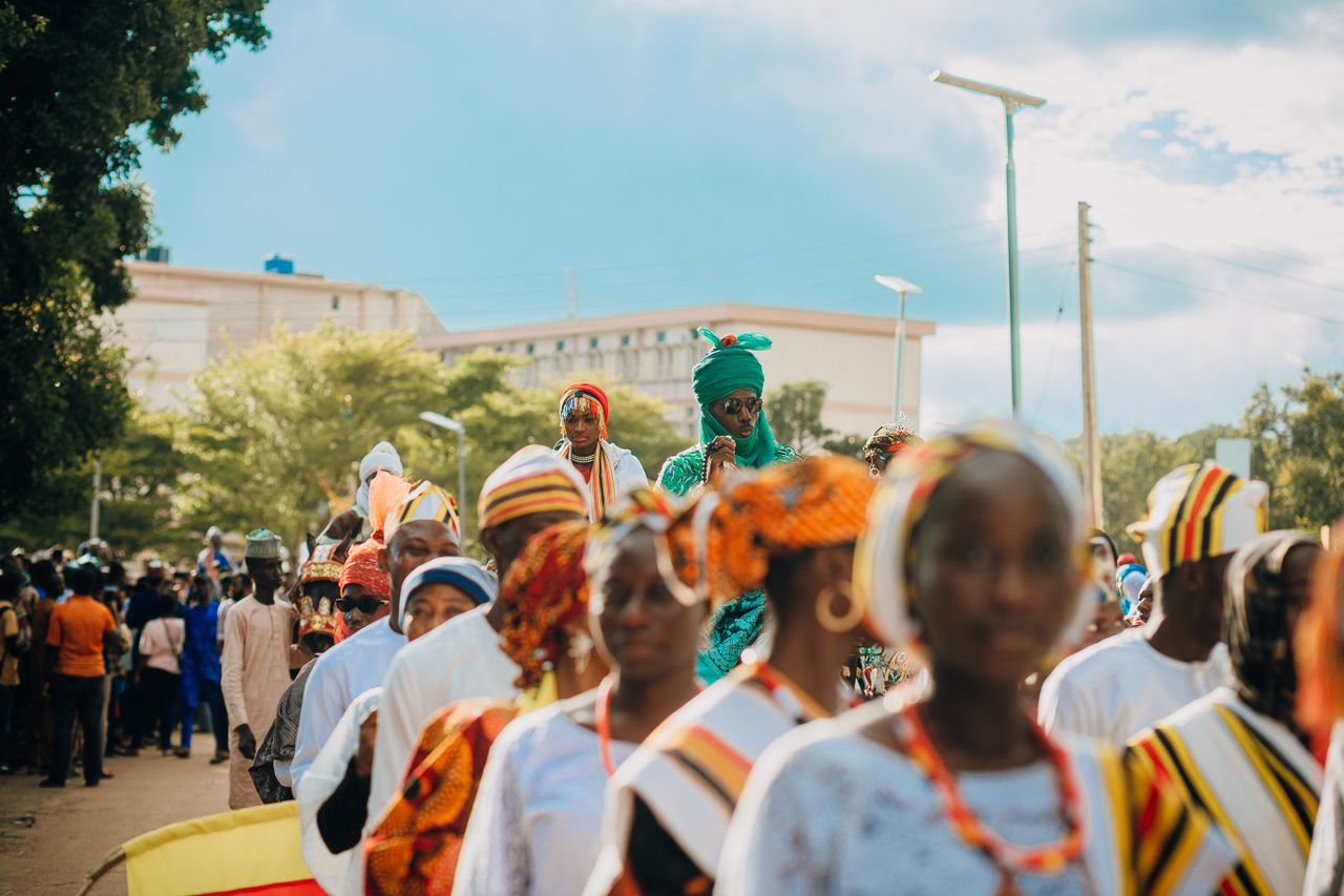 Vibrant street parade in Nigeria showcasing traditional attire and colorful festivities.